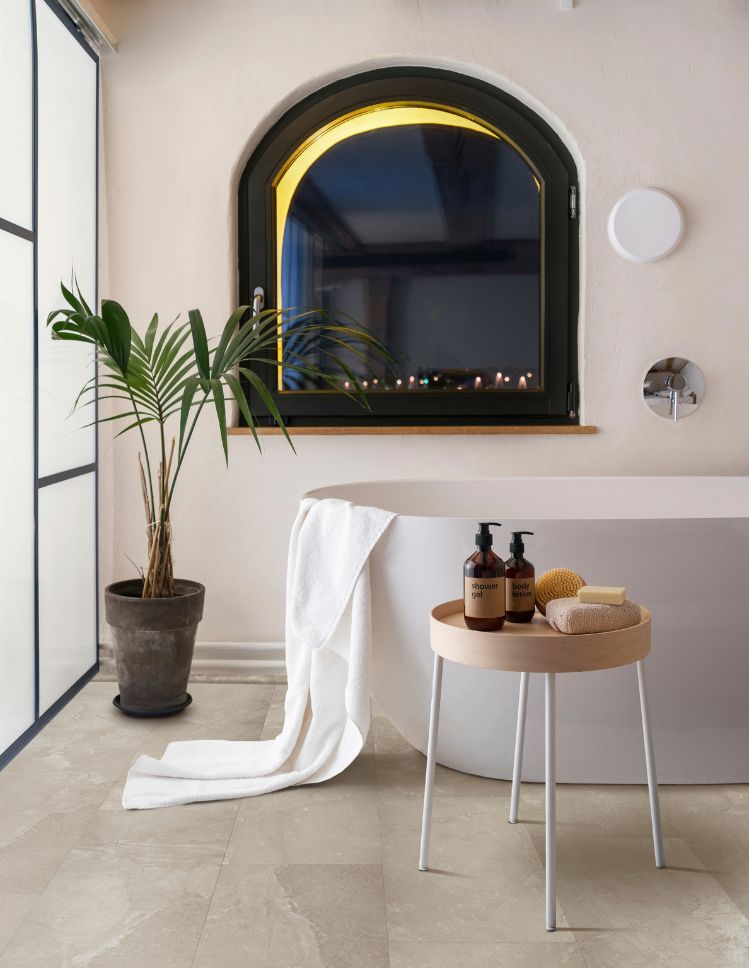 bathroom design with tile floors whitet tub and a window